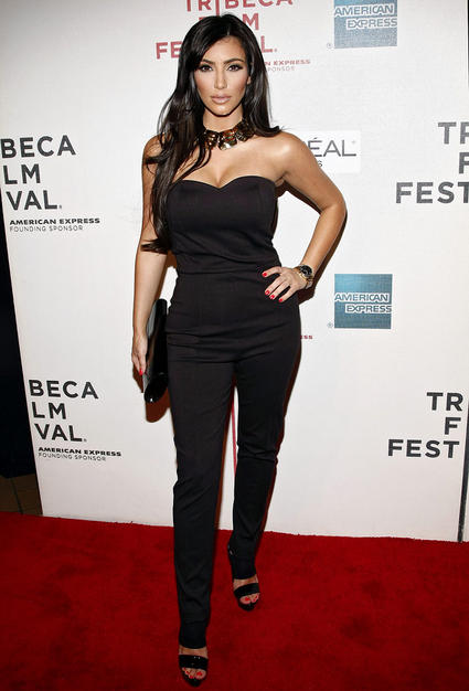 Thankfully, Kim Kardashian ditched her wretched golden weave and rocked the red carpet at the Tribeca Film Fest in a stunning strapless jumpsuit, metallic choker, and bright red nails.